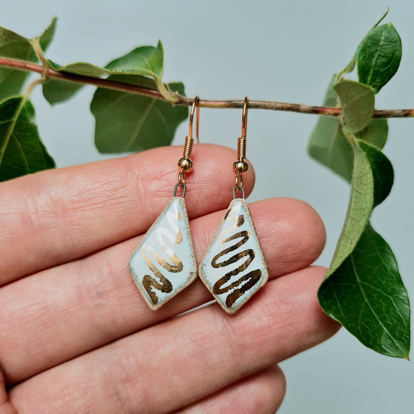 Handmade ceramic white diamond shaped earrings with 24c gold swirl detail